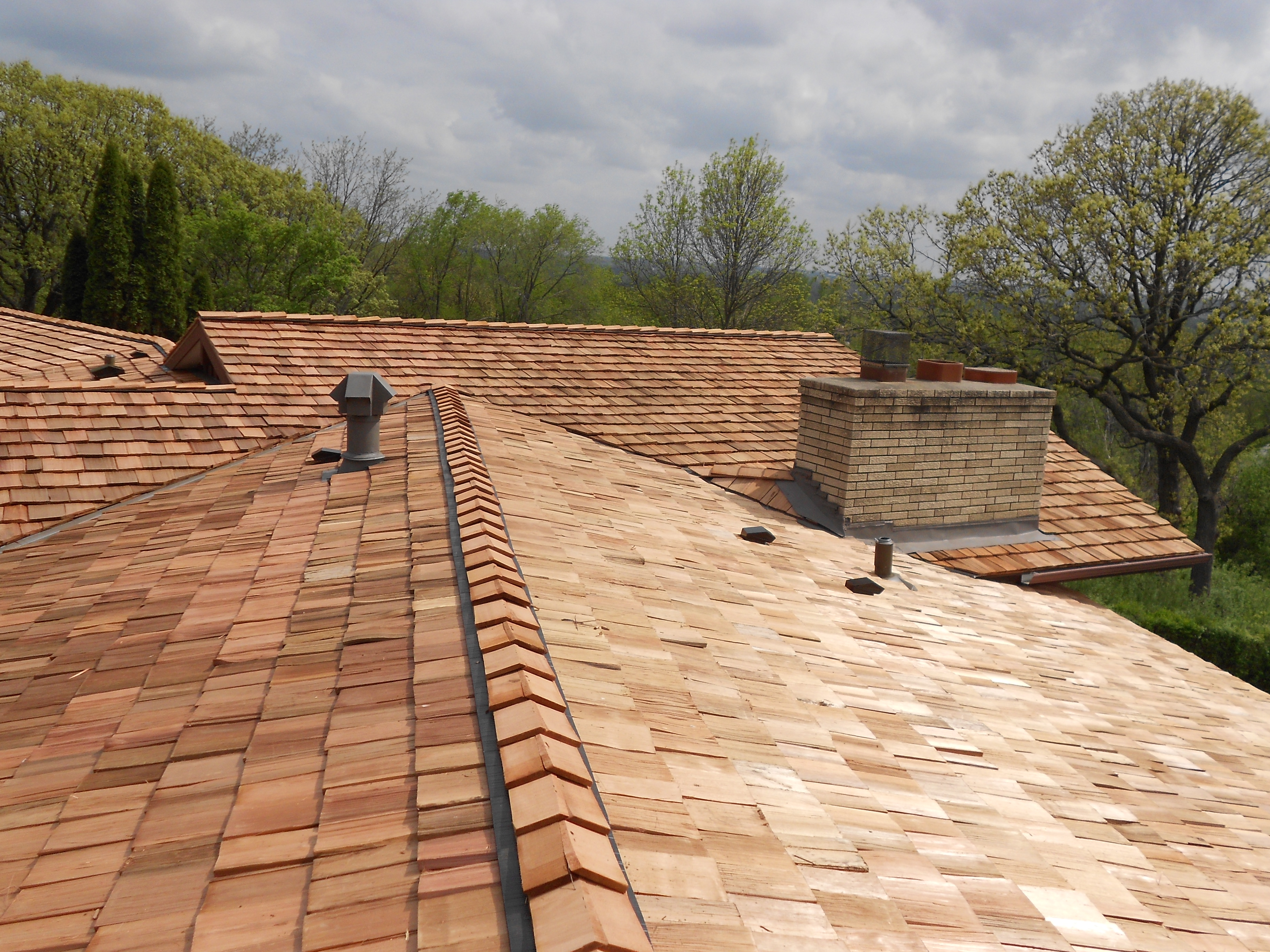 Cedar shake wood shingle roof installation with chimney flashing and valley metal detail — Northern Forge Construction specialty roofing in the north Minneapolis metro, MN